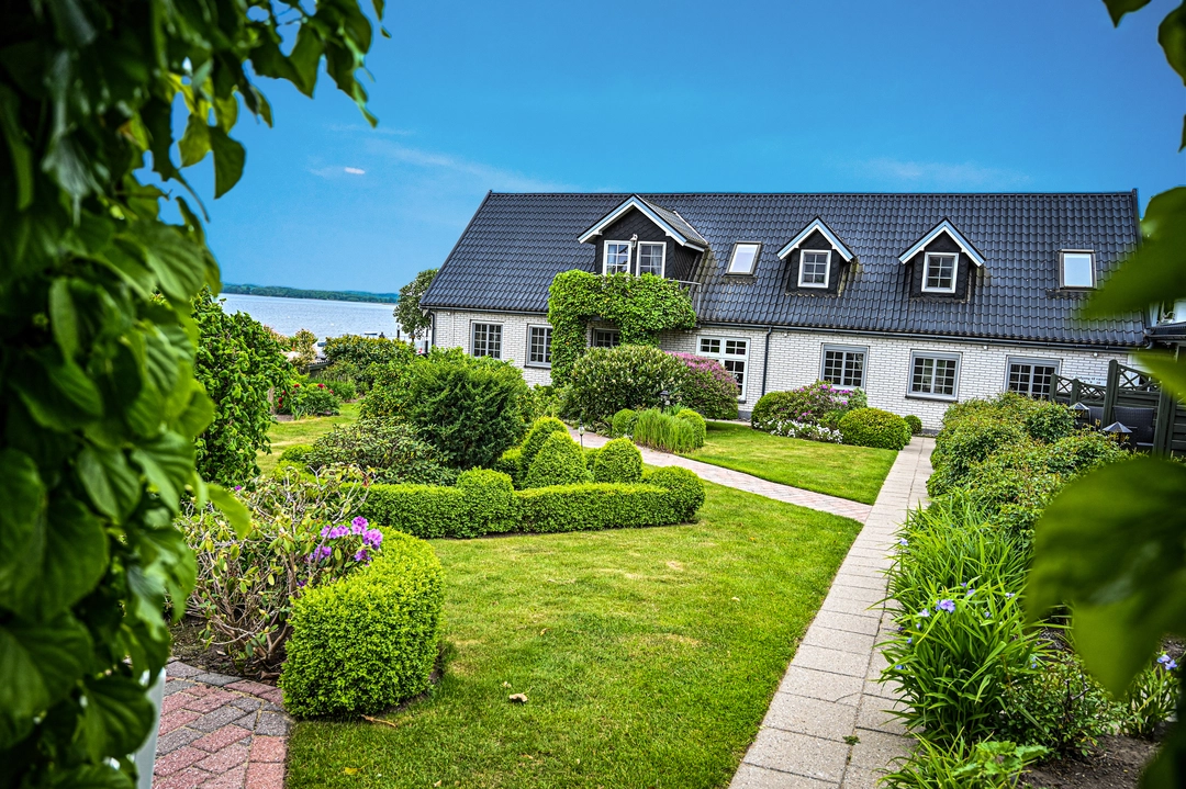 Billede af Hotel Fjordkroens grønne have med blå himmel